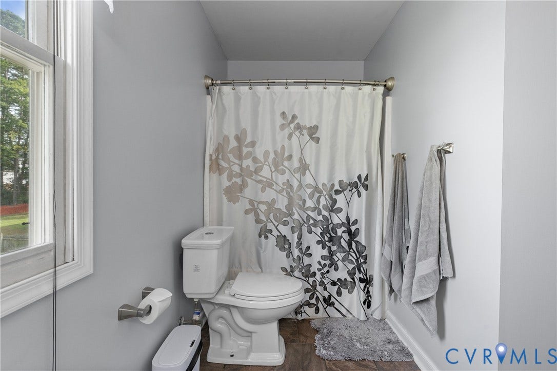 7625 Southford Lane, Chesterfield, VA 23832 White wall-mounted toilet with a brushed nickel toilet paper holder