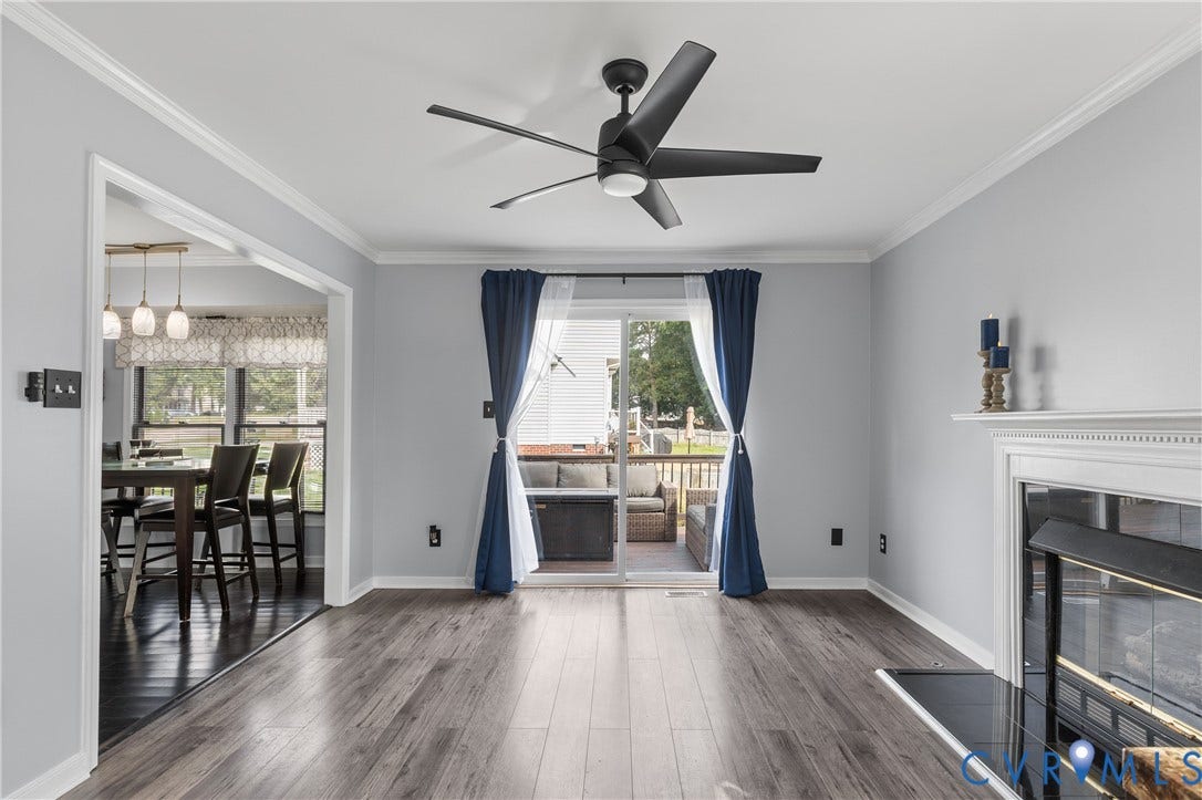 7625 Southford Lane, Chesterfield, VA 23832 Wood-finish flooring, white crown molding, a built-in fireplace, a ceiling fan with integrated lighting, and sliding glass doors to an outdoor deck