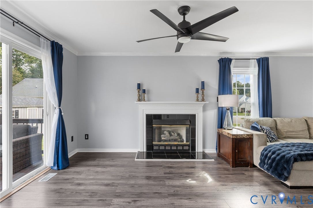 7625 Southford Lane, Chesterfield, VA 23832 Wood-finish flooring, white mantel fireplace with black surround, sliding glass door, and a black ceiling fan