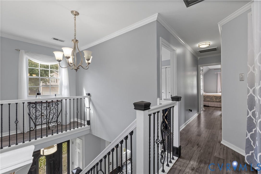 7625 Southford Lane, Chesterfield, VA 23832 Upper-level landing featuring wood-finish flooring, white crown molding, a decorative chandelier, and wrought iron balusters