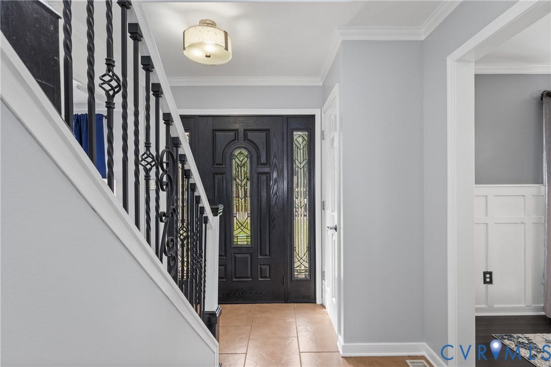 7625 Southford Lane, Chesterfield, VA 23832 Entry foyer featuring a decorative front door with leaded glass sidelights, ceramic tile flooring, and a wrought iron staircase railing
