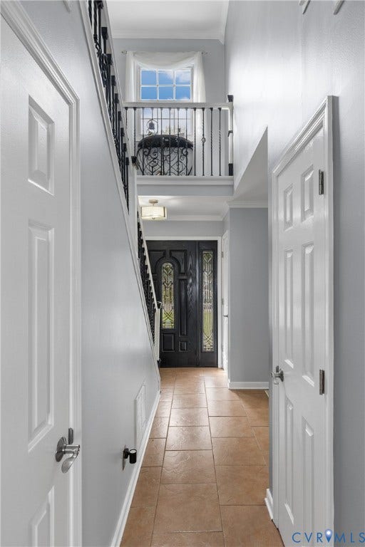 7625 Southford Lane, Chesterfield, VA 23832 Foyer featuring tile flooring, a staircase with wrought iron balusters, a decorative front door with leaded glass, and a second-story landing with a window