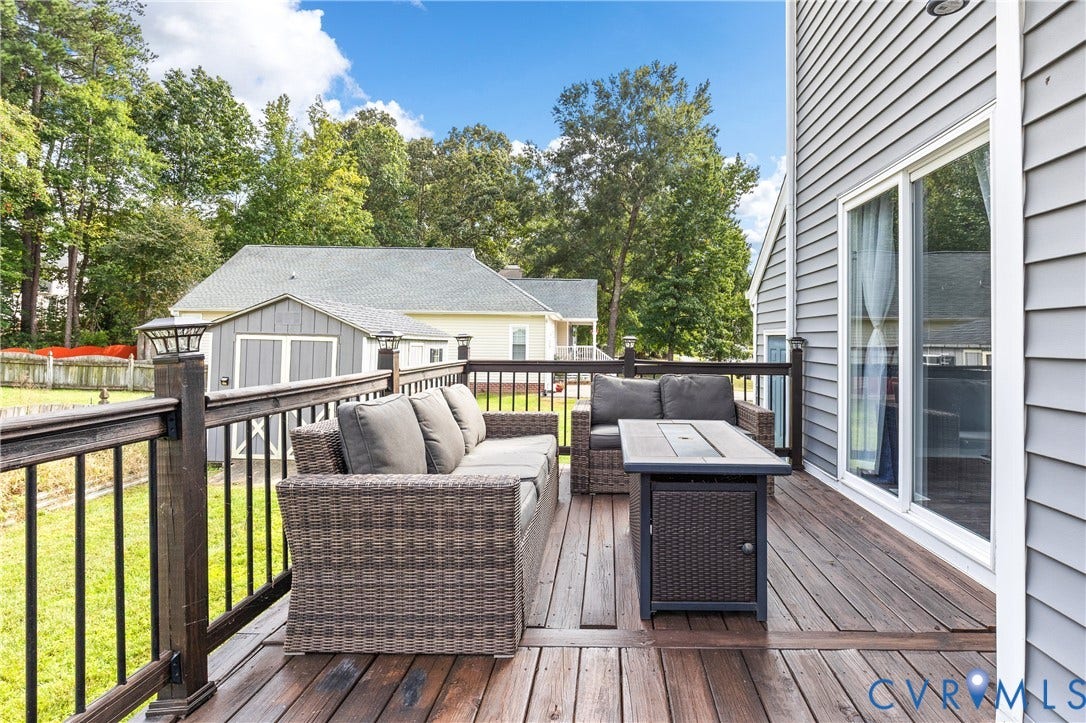 7625 Southford Lane, Chesterfield, VA 23832 Hardwood deck with dark railings and integrated post lighting, featuring a sliding glass door and gray horizontal siding