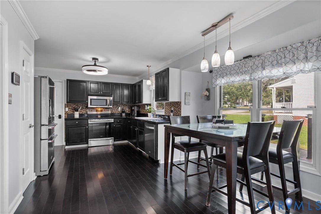 7625 Southford Lane, Chesterfield, VA 23832 Dark wood-finish flooring, black cabinetry, stainless steel appliances, and a window with a multi-light pendant fixture
