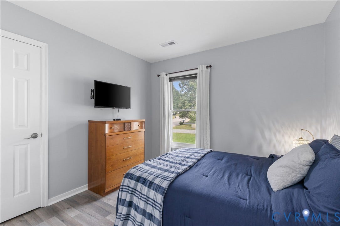 7625 Southford Lane, Chesterfield, VA 23832 Wood-finish flooring, light gray wall paint, and a window with white curtains
