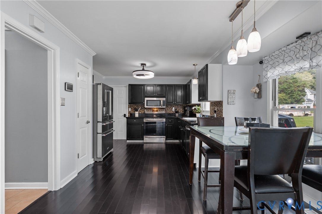 7625 Southford Lane, Chesterfield, VA 23832 Kitchen featuring wood-finish flooring, dark cabinetry, stainless steel appliances, and a tiled backsplash