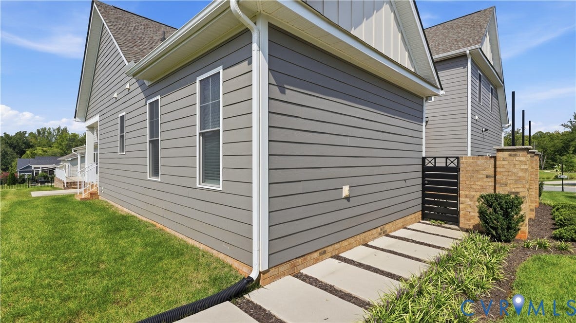 Gray horizontal siding exterior with a brick foundation and white trim