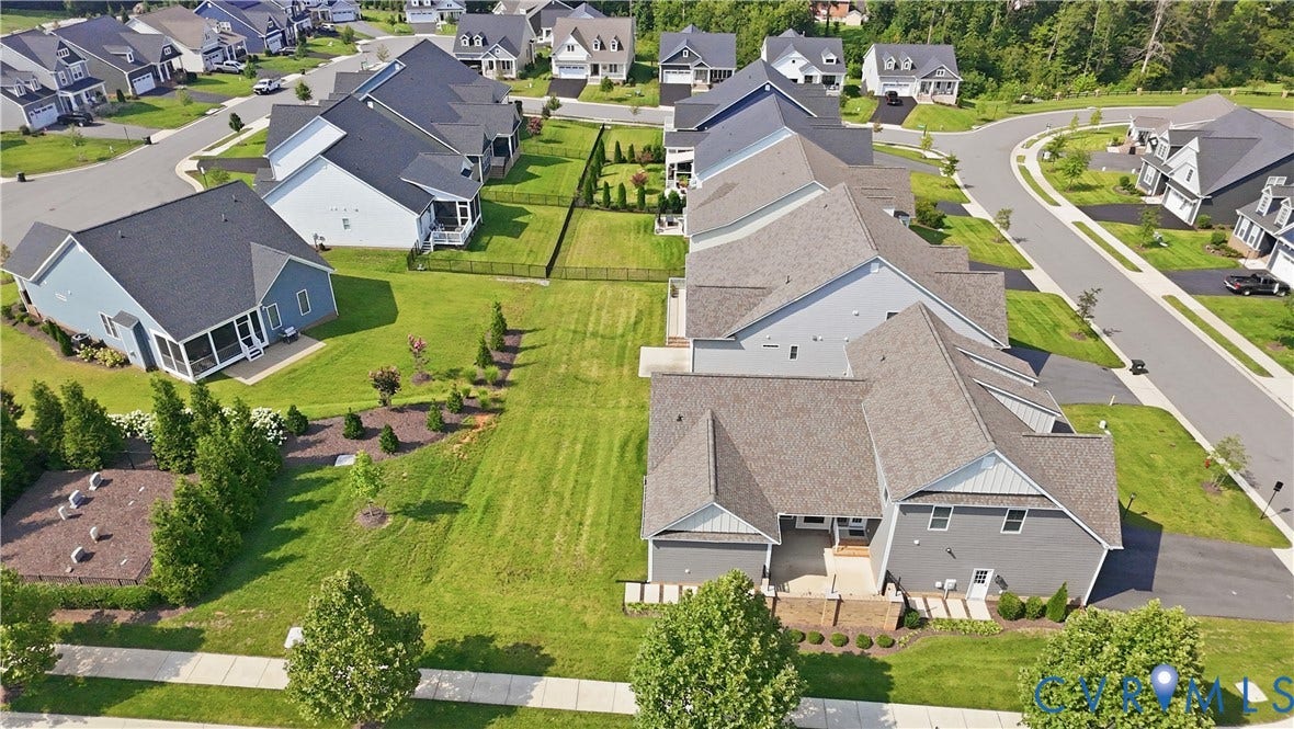 Aerial perspective showcasing a residential community with paved streets, landscaped properties, and mature trees
