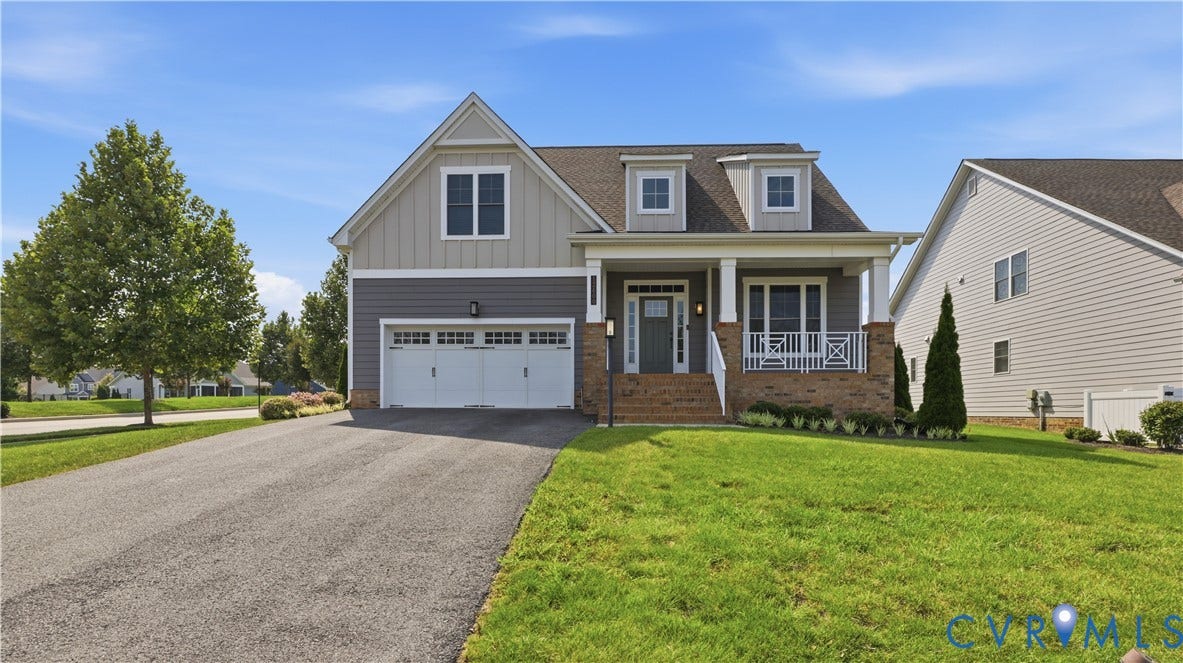Craftsman-style home featuring a two-car garage, dormer windows, and a covered front porch with white railings