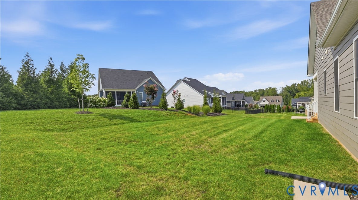 Expansive green lawn with mature trees and landscaping