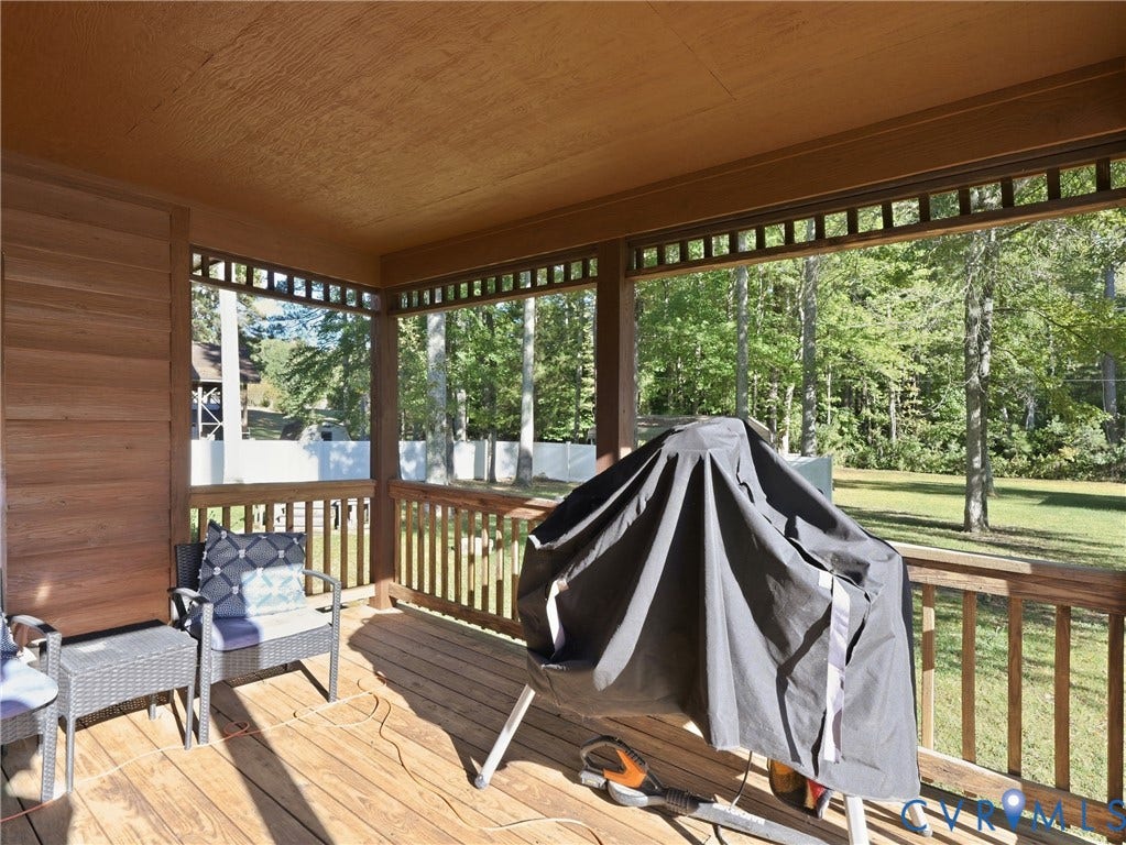 6723 Bull Hill Road, Prince George, VA 23875 Covered wooden deck featuring horizontal wood-plank siding, decorative lattice trim, and wooden railing