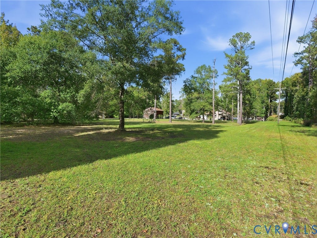 6723 Bull Hill Road, Prince George, VA 23875 Expansive lot featuring mature trees, open grassy terrain, and an existing detached covered structure