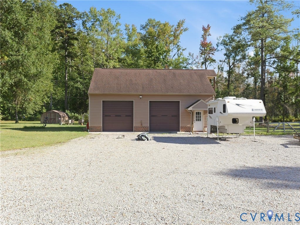 6723 Bull Hill Road, Prince George, VA 23875 Detached two-bay garage featuring a pitched shingle roof, neutral siding, and a gravel driveway