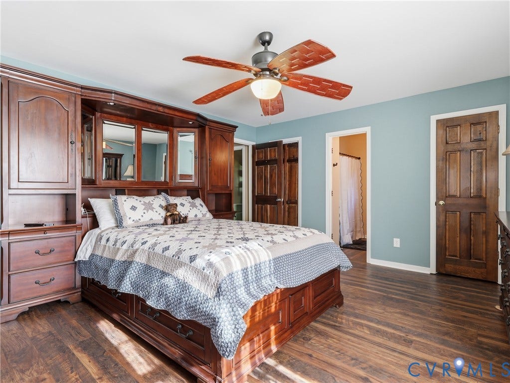 6723 Bull Hill Road, Prince George, VA 23875 Built-in wood cabinetry with mirror accents, wood-finish flooring, six-panel wood doors, and a ceiling fan with integrated lighting