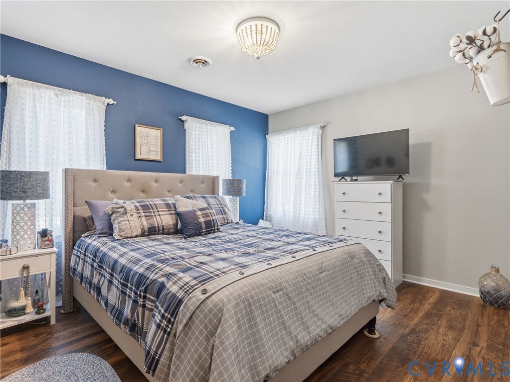 6723 Bull Hill Road, Prince George, VA 23875 Room featuring wood-finish flooring, a bold blue accent wall, and a decorative semi-flush mount ceiling fixture