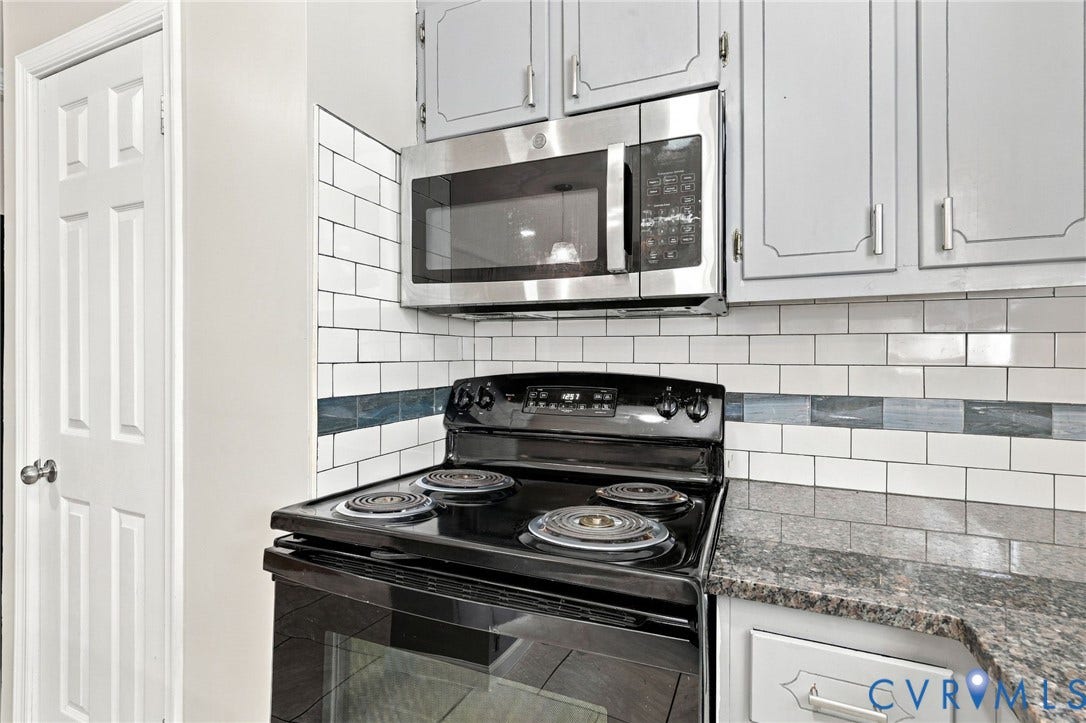 1432 Ferndale Avenue, Petersburg, VA 23803 Kitchen featuring a black electric range, stainless steel microwave, light gray cabinetry, subway tile backsplash, and granite-style countertops
