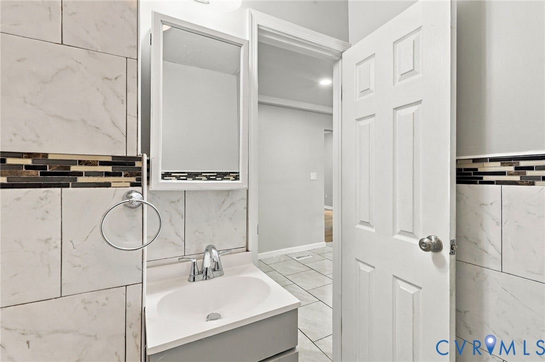 1432 Ferndale Avenue, Petersburg, VA 23803 Vanity with an integrated sink, polished chrome faucet, and mirrored medicine cabinet