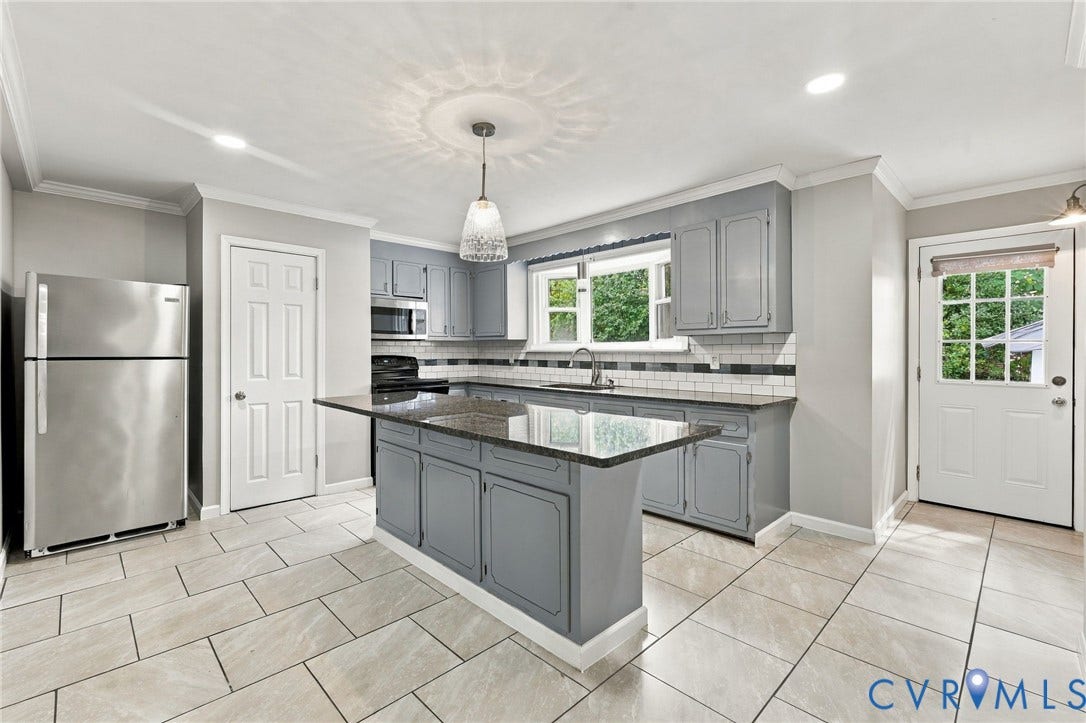 1432 Ferndale Avenue, Petersburg, VA 23803 Kitchen featuring light gray cabinetry, a central island with a dark countertop, stainless steel appliances, a white subway tile backsplash, and light-toned rectangular floor tiles
