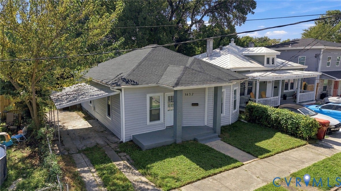 1432 Ferndale Avenue, Petersburg, VA 23803 Light gray siding exterior with dark gray trim, featuring a covered front porch and a paved driveway with a carport