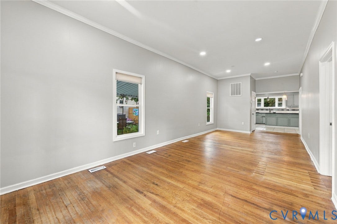 1432 Ferndale Avenue, Petersburg, VA 23803 Hardwood flooring, recessed lighting, crown molding, white trim, and a glimpse of the kitchen with painted cabinetry