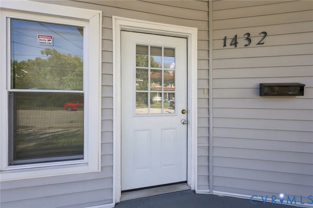 1432 Ferndale Avenue, Petersburg, VA 23803 White paneled door with divided lite window, gray horizontal siding, and dark-finish house numbers
