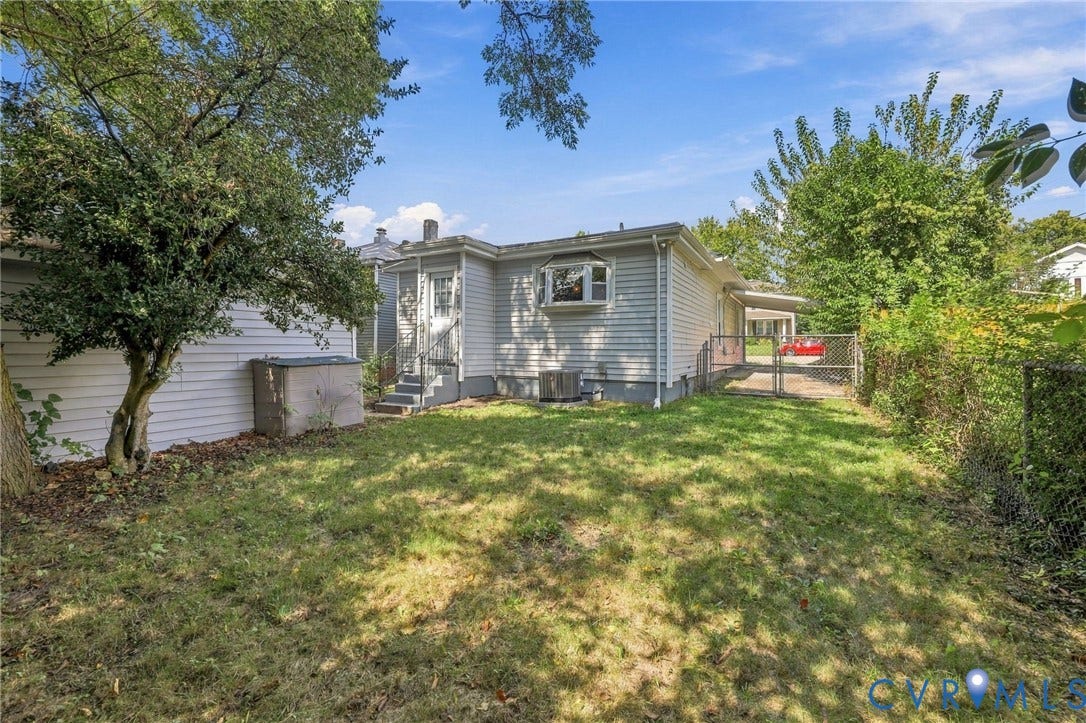 1432 Ferndale Avenue, Petersburg, VA 23803 Expansive grassy yard with mature trees and a chain-link fence