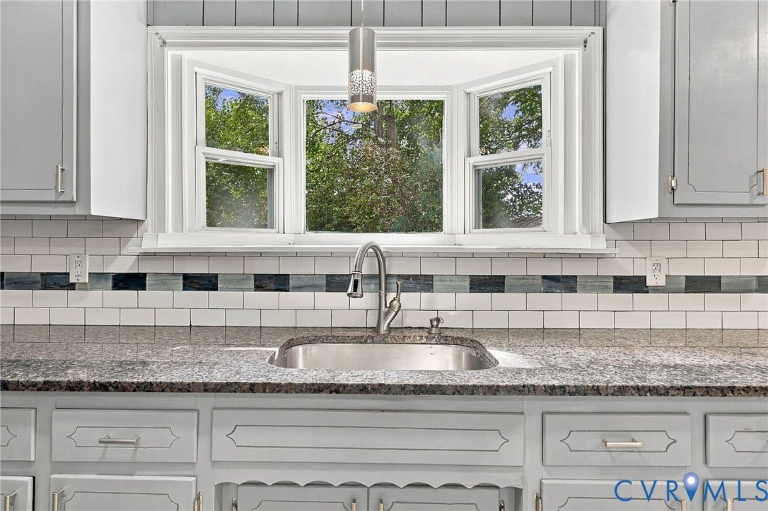 1432 Ferndale Avenue, Petersburg, VA 23803 Bay window with white trim, undermount stainless steel sink, gooseneck faucet, light gray countertops, and subway tile backsplash with decorative accent