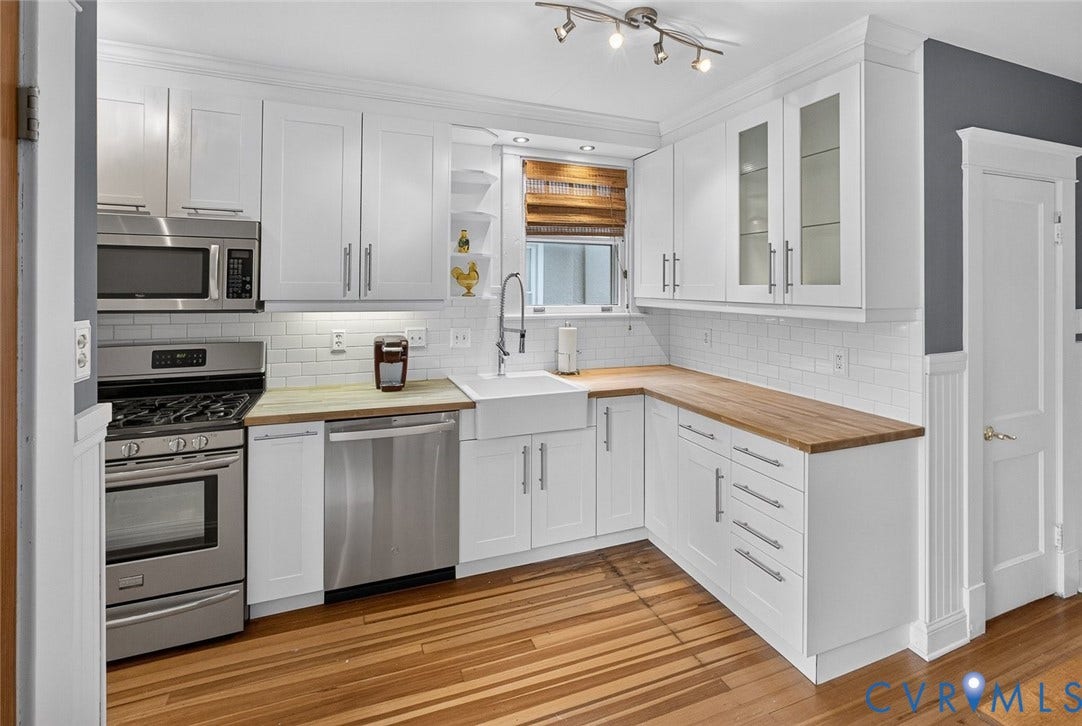 3812 Fauquier Avenue, Bellevue, Richmond, VA 23227 White shaker cabinetry, stainless steel appliances, butcher block countertops, subway tile backsplash, and wood-finish flooring