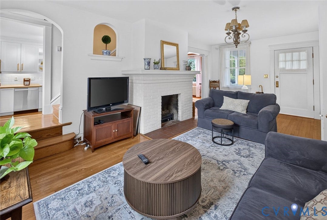 3812 Fauquier Avenue, Bellevue, Richmond, VA 23227 Hardwood flooring, painted brick fireplace, arched entryway, decorative wall niche, and an ornate chandelier