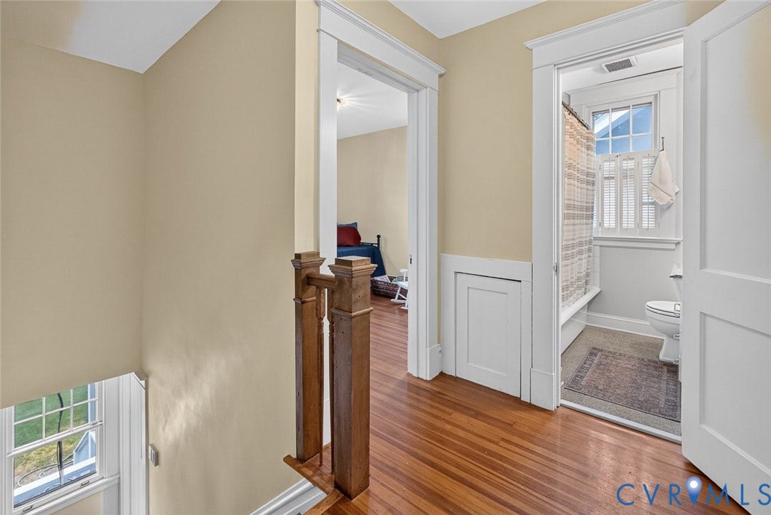 3812 Fauquier Avenue, Bellevue, Richmond, VA 23227 Hardwood flooring, painted wainscoting, white trim, wood newel post, and a bathroom featuring a window with privacy shutters