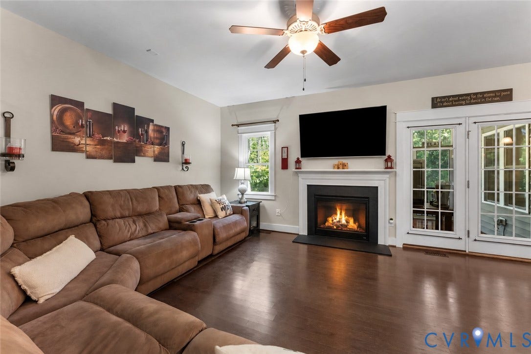 6446 Chestnut Church Road, Mechanicsville, VA 23116 Wood-finish flooring with a ceiling fan, fireplace with white mantel, and double glass-paneled doors