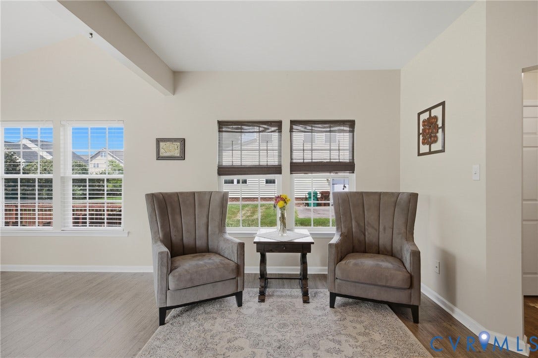 3536 Hunton Ridge Drive, Glen Allen, VA 23059 Vaulted ceiling with an exposed beam, multiple windows with white louvered shutters, light wood-finish flooring, and neutral wall tones