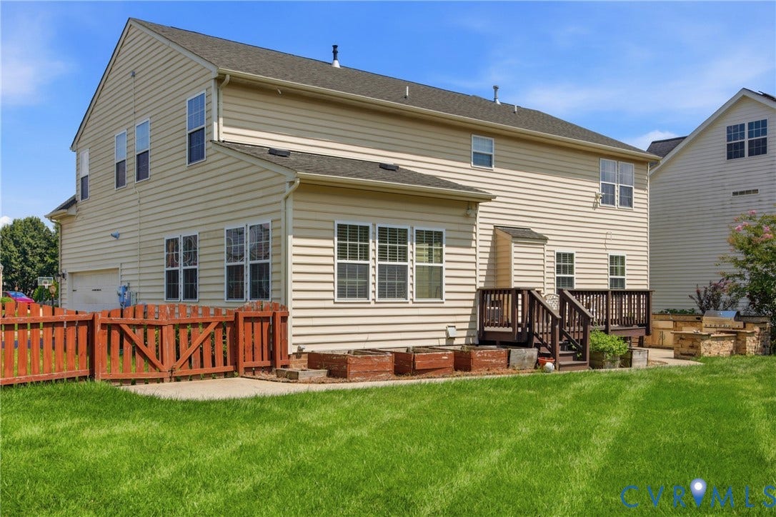 3536 Hunton Ridge Drive, Glen Allen, VA 23059 Expansive backyard with a manicured lawn, multi-level wood deck, privacy fencing, and raised garden beds
