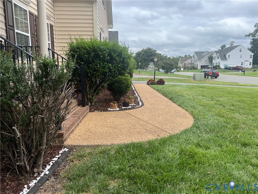 3536 Hunton Ridge Drive, Glen Allen, VA 23059 Exposed aggregate concrete walkway with a manicured lawn, brick foundation, and dark window shutters