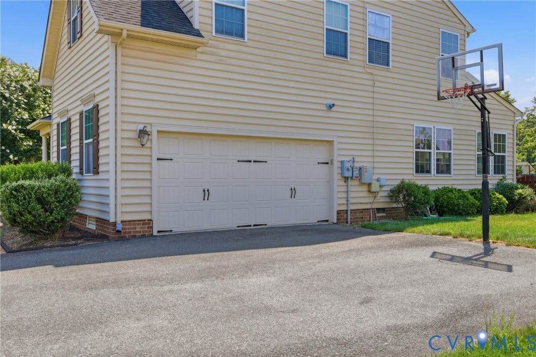 3536 Hunton Ridge Drive, Glen Allen, VA 23059 Two-car garage with paneling and decorative hardware, asphalt driveway, horizontal siding, and multiple windows