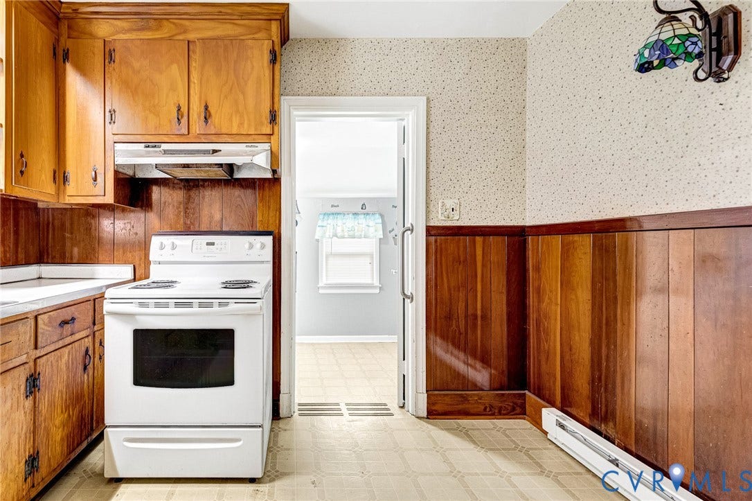 2503 Carlisle Avenue, Henrico, VA 23231 Wood cabinetry, white countertop, white electric range, wood paneling, and patterned flooring