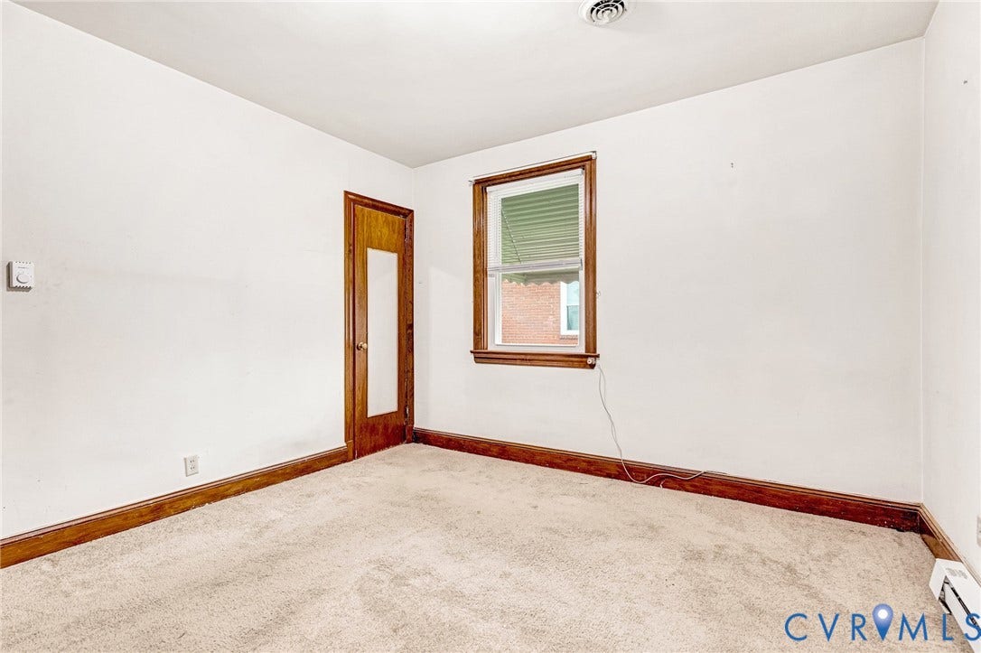 2503 Carlisle Avenue, Henrico, VA 23231 Carpeted flooring with wood trim, window with blinds, and wooden door featuring a partial glass panel