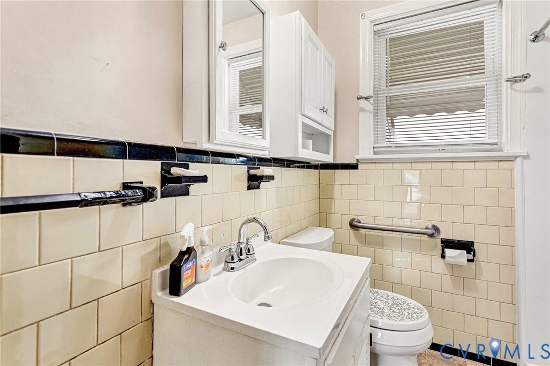 2503 Carlisle Avenue, Henrico, VA 23231 Bathroom with wall-mounted medicine cabinet, white vanity with integrated sink, toilet, tiled walls, and window