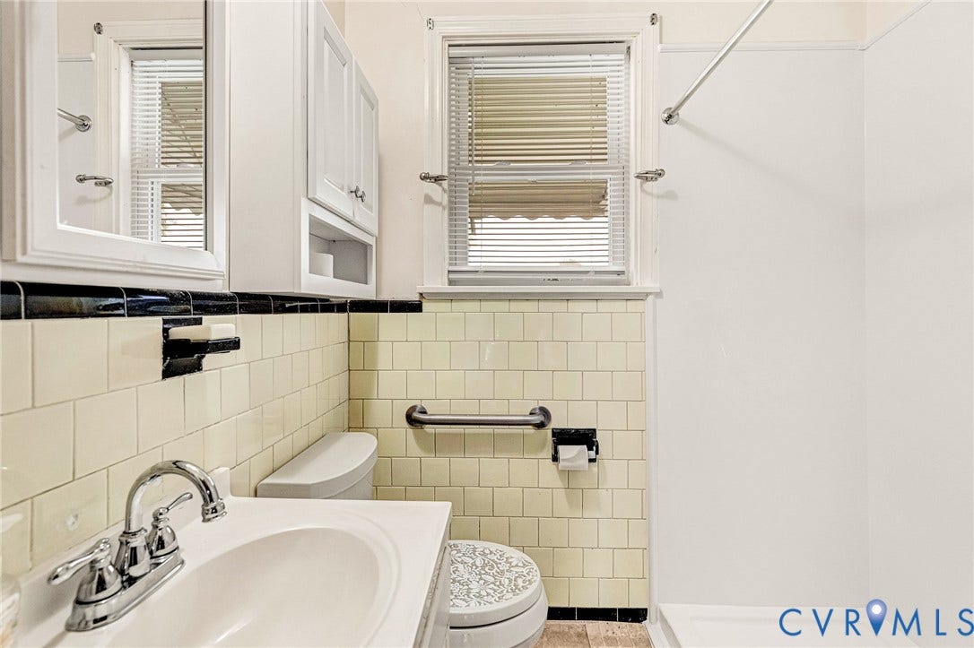 2503 Carlisle Avenue, Henrico, VA 23231 Bathroom featuring a vanity with an integrated sink, wall-mounted medicine cabinet, built-in storage cabinet, and tiled walls
