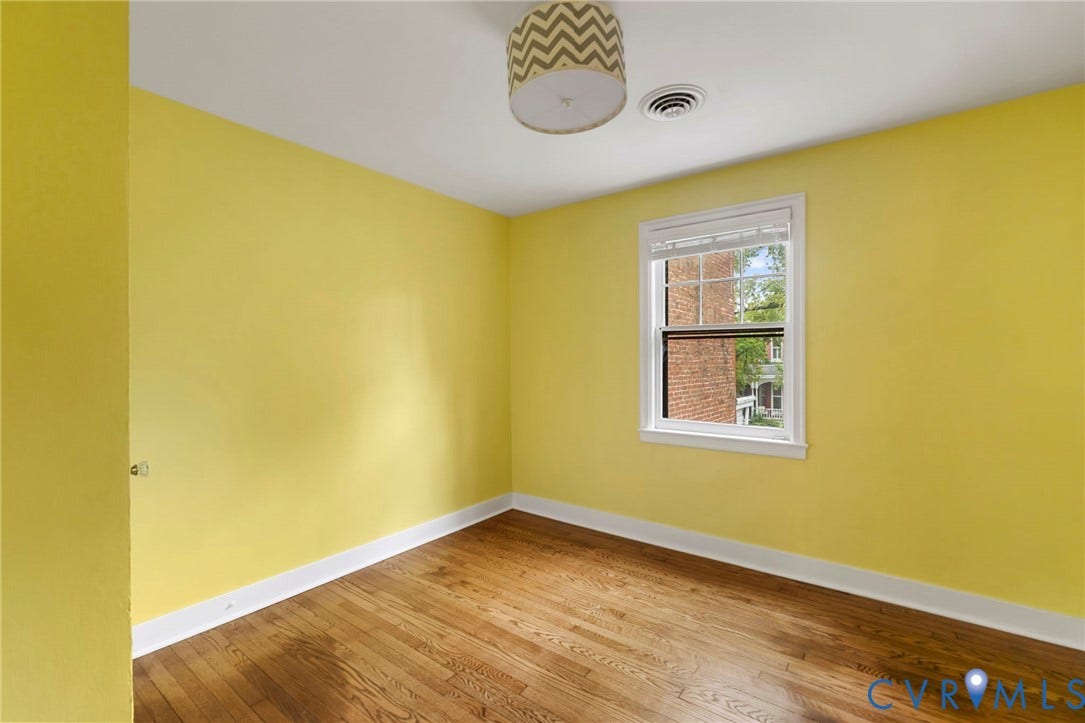 2714 E Broad Street, Church Hill, Richmond, VA 23223 Hardwood flooring, painted walls, single window with white trim, and a ceiling-mounted light fixture