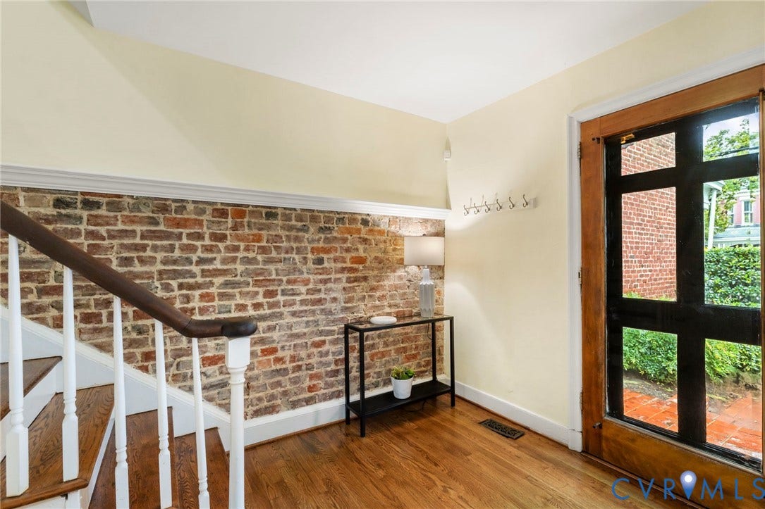 2714 E Broad Street, Church Hill, Richmond, VA 23223 Hardwood flooring, exposed brick wall, wood paneled front door with glass inserts, white staircase with wood handrail, crown molding