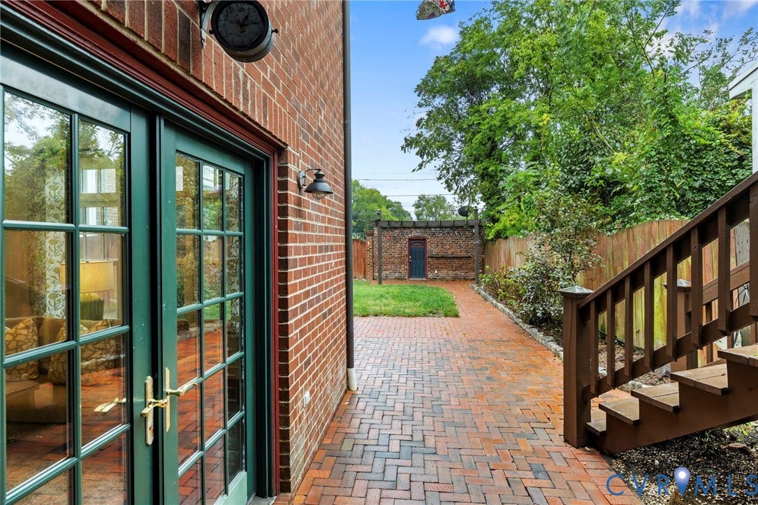 2714 E Broad Street, Church Hill, Richmond, VA 23223 Brick exterior with double glass-paned doors, a brick paver pathway, and wood-finish stairs