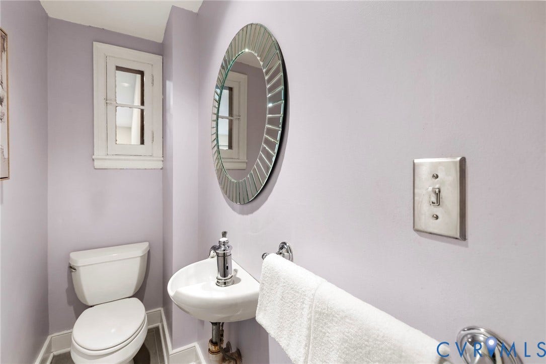 2714 E Broad Street, Church Hill, Richmond, VA 23223 White pedestal sink with chrome faucet, toilet, and a decorative circular mirror