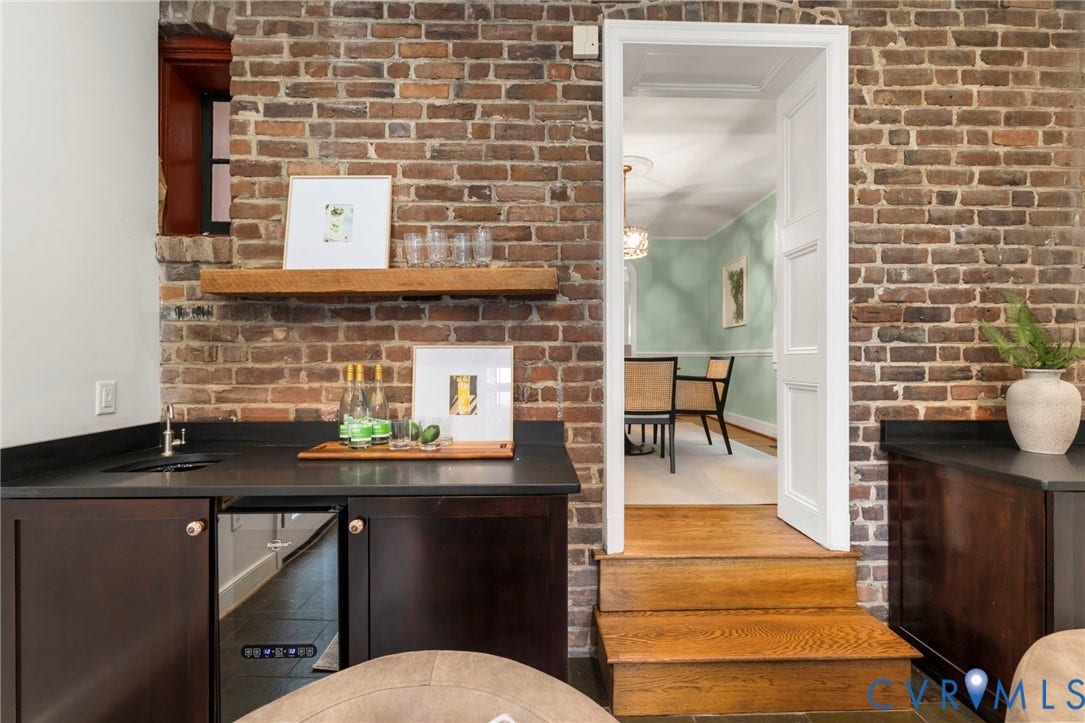 2714 E Broad Street, Church Hill, Richmond, VA 23223 Exposed brick wall with built-in cabinetry, dark countertops, and an integrated beverage refrigerator