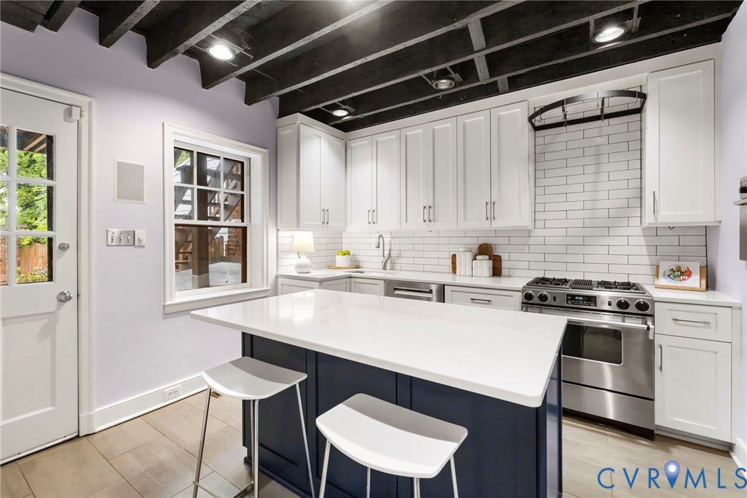 2714 E Broad Street, Church Hill, Richmond, VA 23223 Kitchen featuring white shaker cabinetry, stainless steel range, white subway tile backsplash, a dark-toned kitchen island with a light-toned countertop, and wood-finish flooring