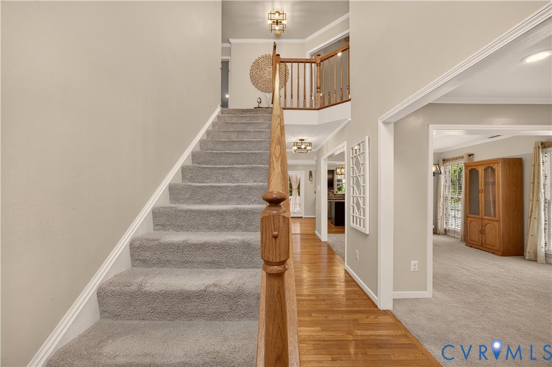 9516 Hungary Woods Drive, Henrico, VA 23060 Two-story foyer featuring carpeted staircase, wood banister, and wood-finish flooring