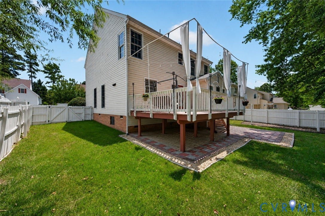 9516 Hungary Woods Drive, Henrico, VA 23060 Expansive backyard featuring a wood deck with white railings, brick paver patio, and white privacy fencing
