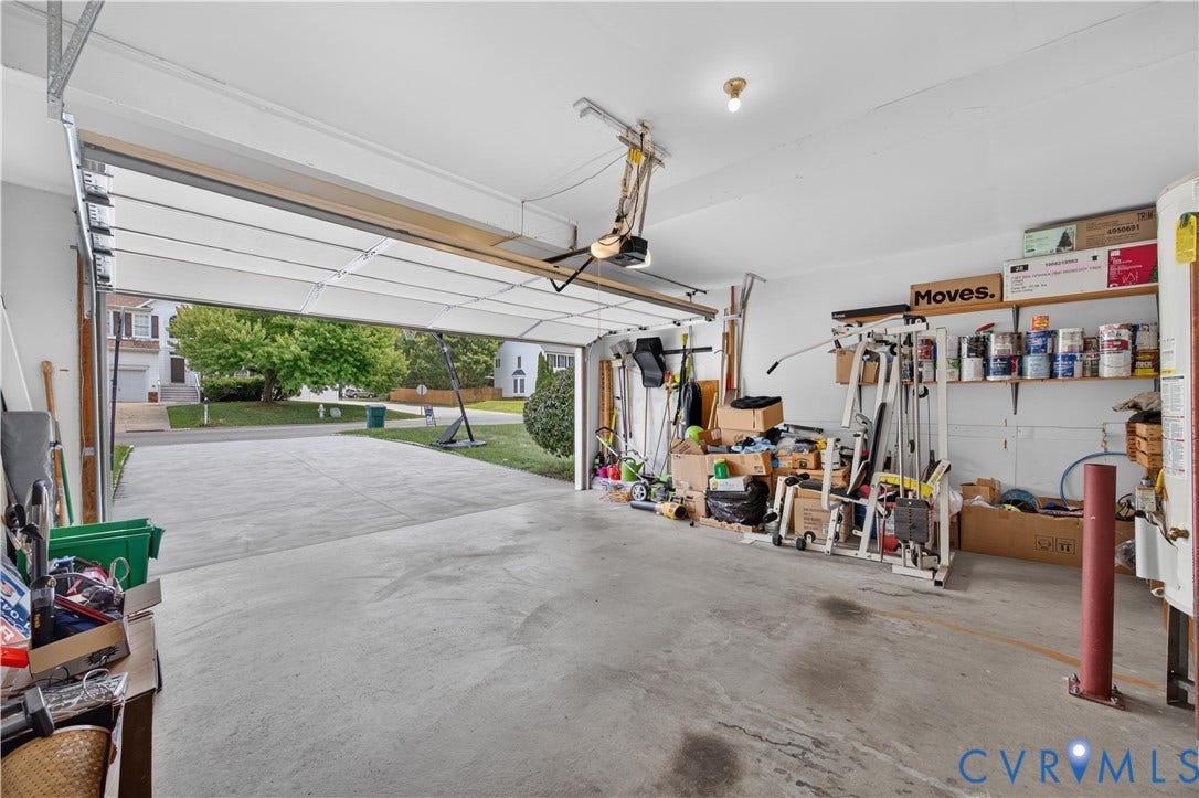 9516 Hungary Woods Drive, Henrico, VA 23060 Spacious garage with an automatic overhead door, concrete flooring, and built-in shelving
