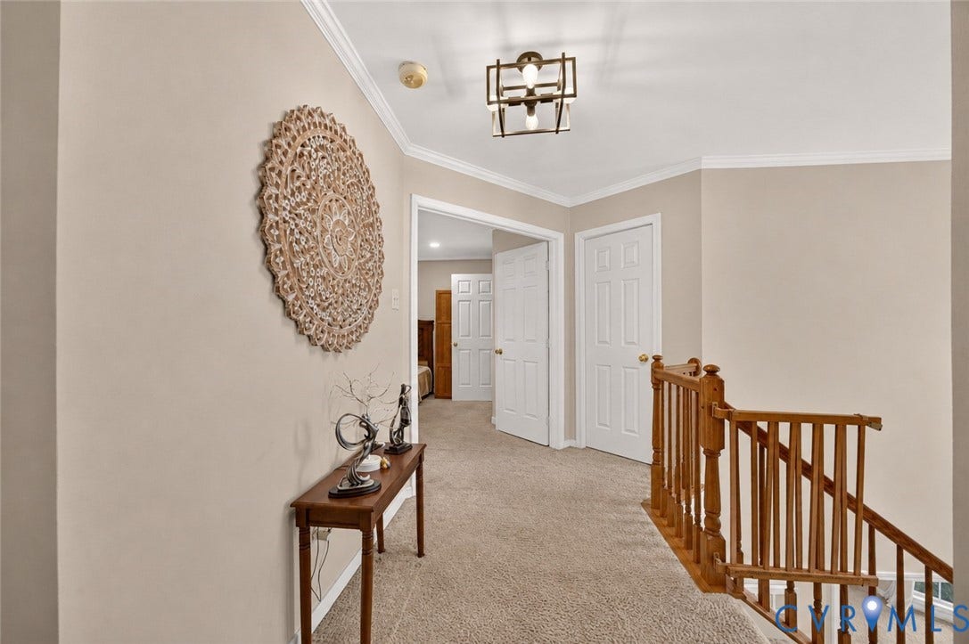 9516 Hungary Woods Drive, Henrico, VA 23060 Carpeted hallway with white interior doors, crown molding, and a wood-finish railing