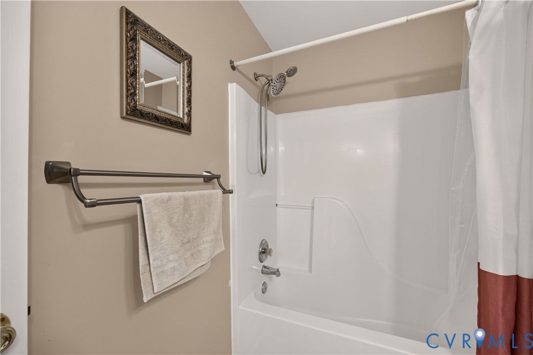 9516 Hungary Woods Drive, Henrico, VA 23060 Bathtub with shower fixture, dual towel bar, and a framed wall mirror
